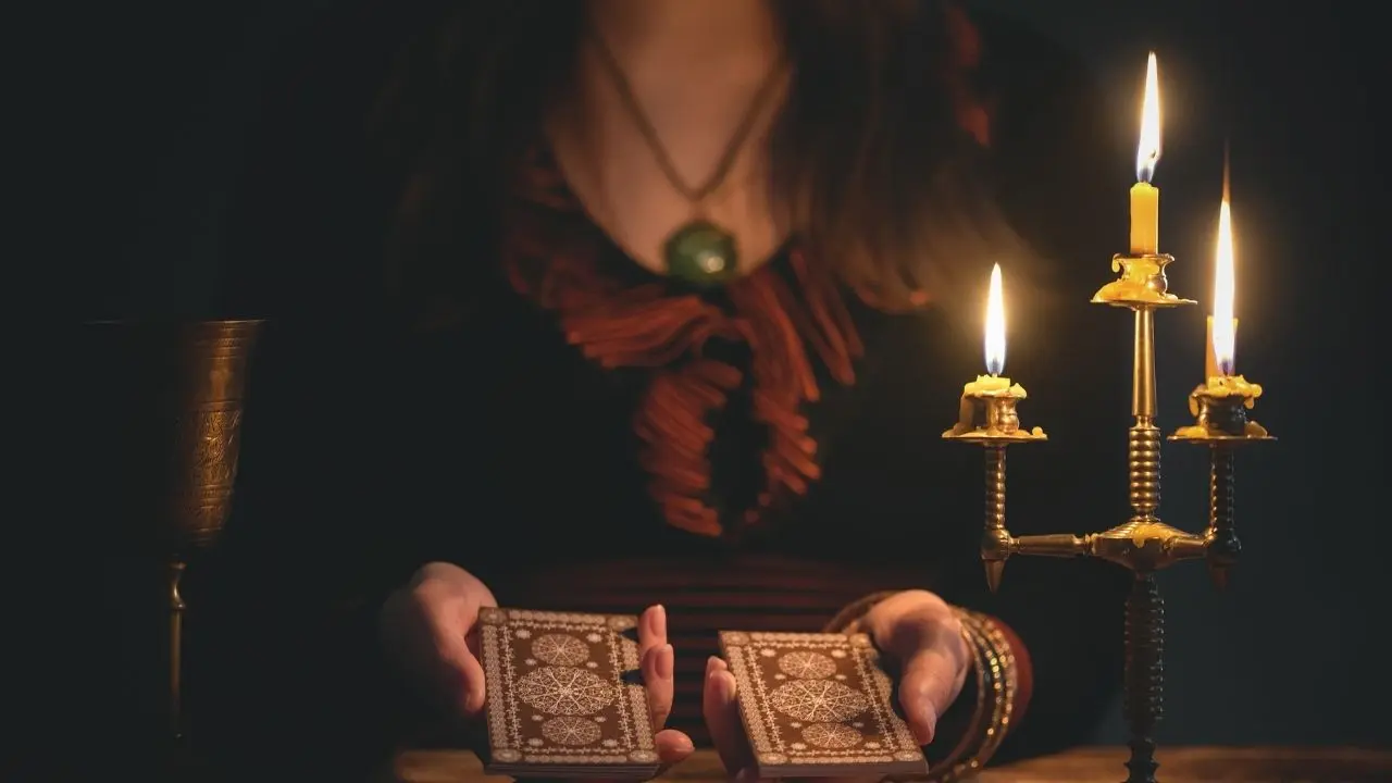 a witch holding tarot cards