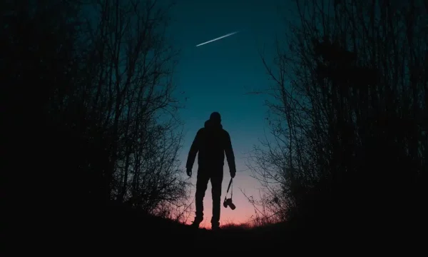 man looking at shooting star